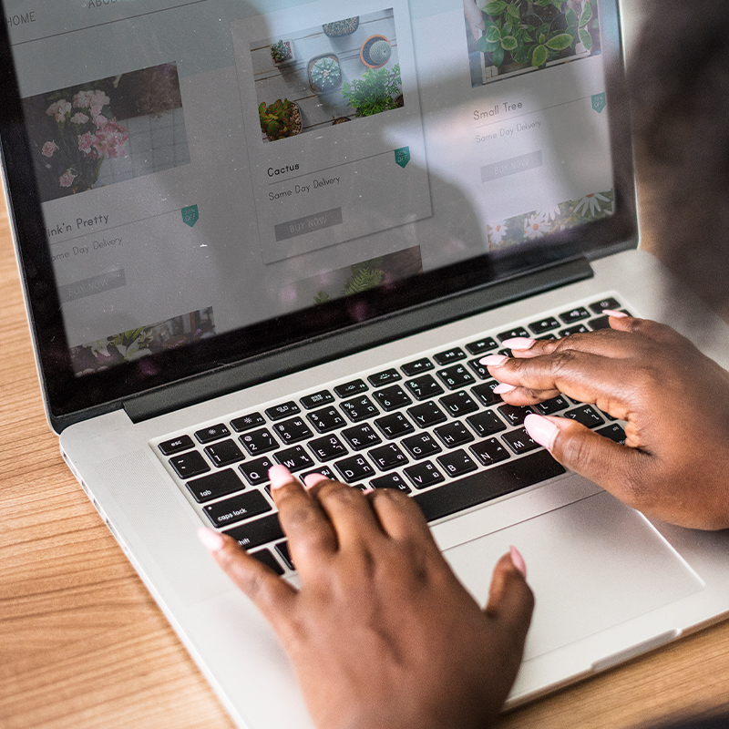 A woman types on a laptop