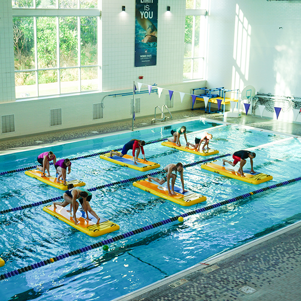 students doing a workout on paddle boards