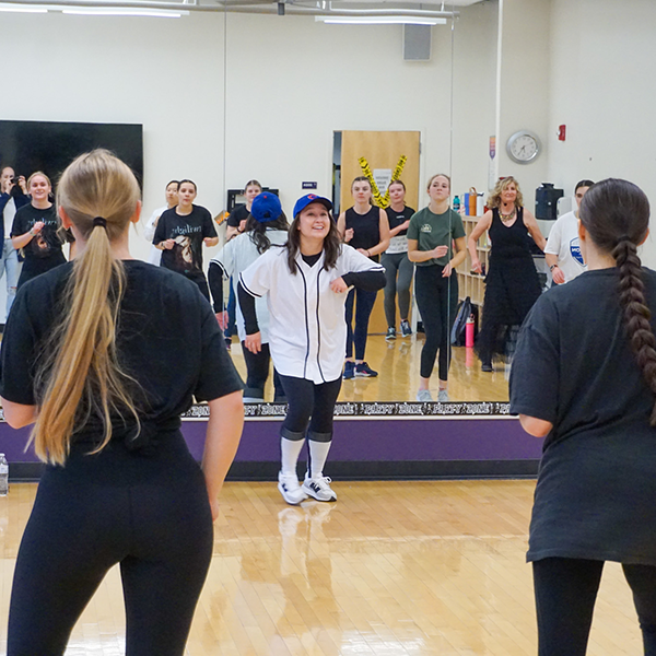 students in halloween costumes looking in a mirror during their workout