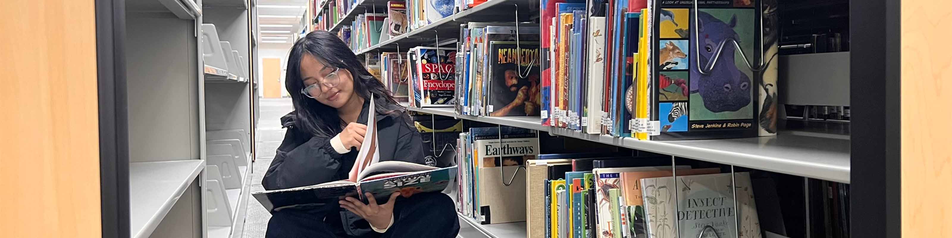 WSU Student reading book in library.