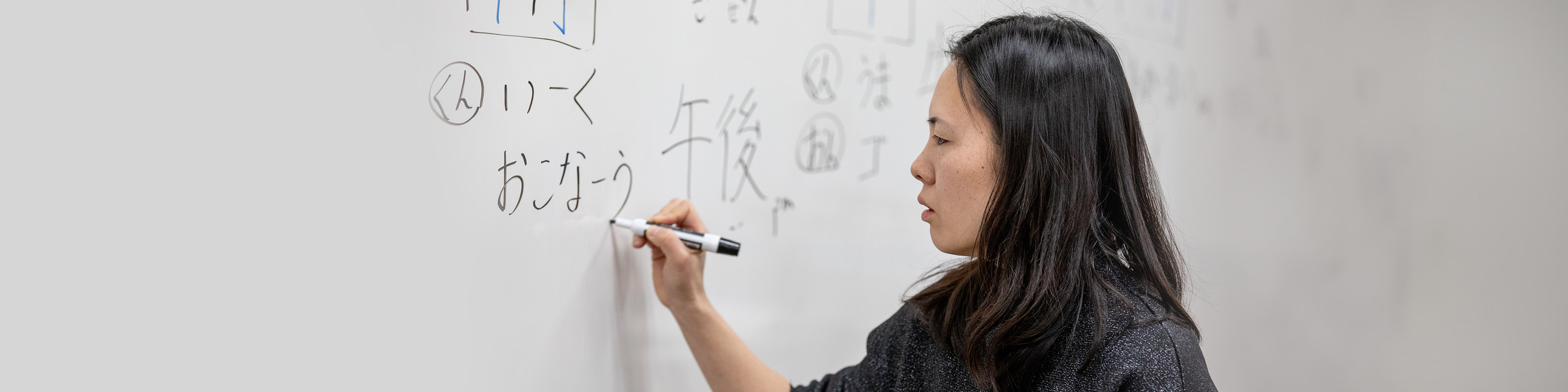 WSU instructor writing on whiteboard.