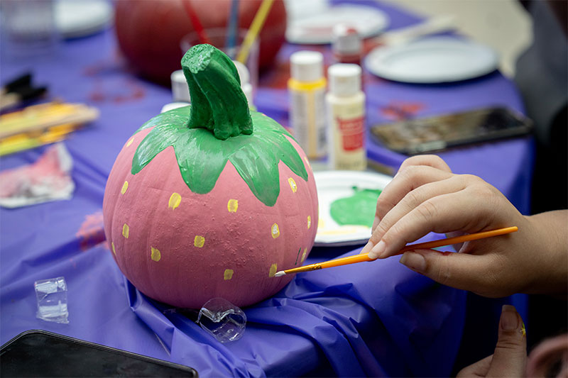 student painting a pumpkin