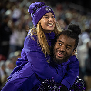 Two students smiling at a football game.