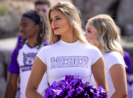 A cheerleader with a purple pompom.