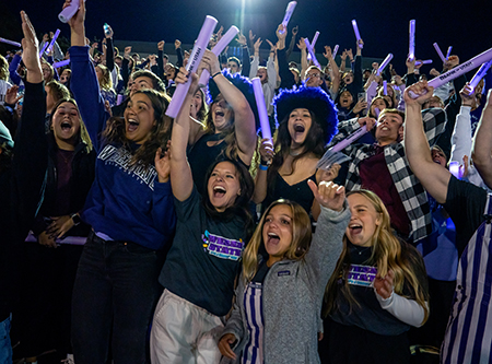 Weber State students cheering in the football stadium stands.