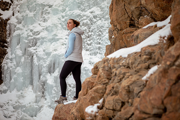 Woman looking at a frozen waterfall