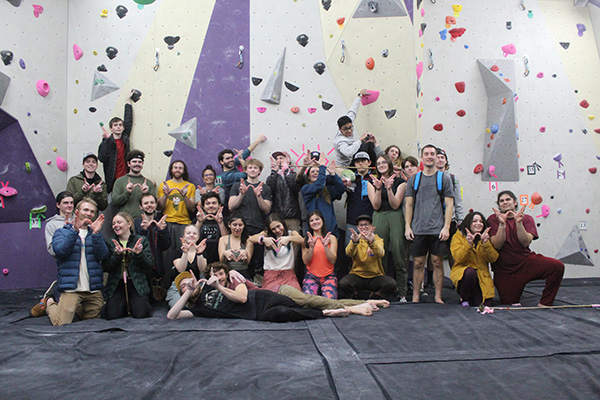 Group of climbing in front of rock climbing wall