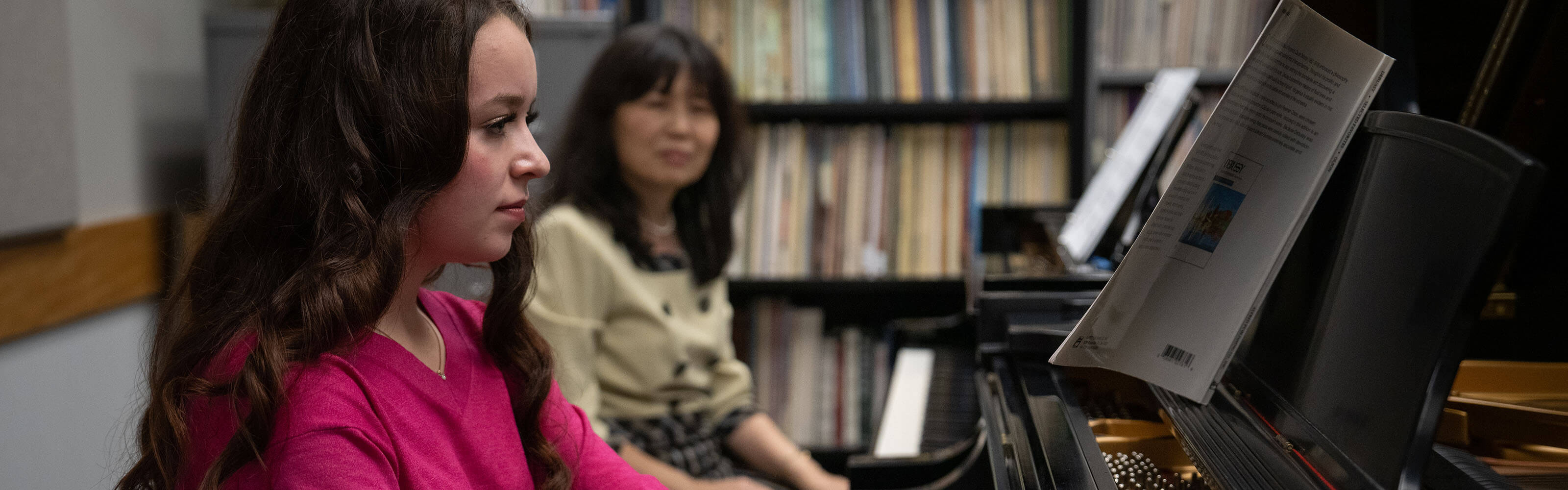 WSU female student taking piano lesson from professor