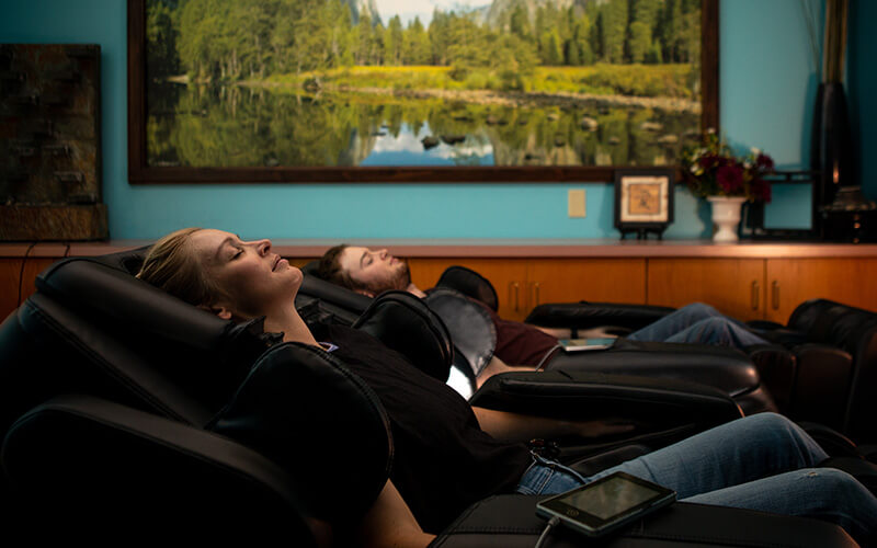 Students relaxing in massage chairs