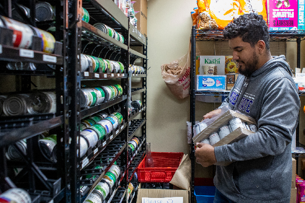 student stocking food at pantry