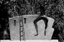 Sulpture of a figure climbing a hogan wall a work by Nora Naranjo-Morse.
